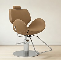 Chaise de barbier élégante au design incurvé, confortable, rembourrée, réglable en hauteur, avec base chromée pour salon de coiffure