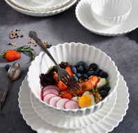 Servies van wit porseleinen kommen en borden met gegolfde rand, milieuvriendelijk, BPA-vrij, voedselveilig, met aangepast logo, modern design, geschikt voor salade en soep.