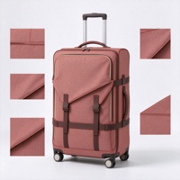 Valise à roulettes souple rouge rouille avec poche avant à rabat à boucle, sangles de compression et poignée télescopique