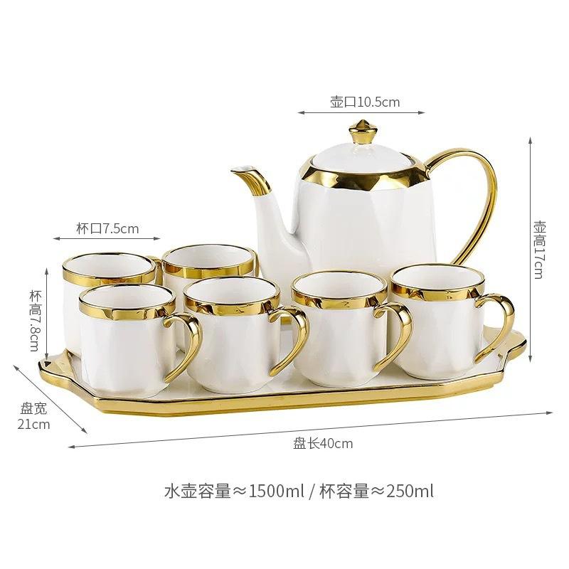 Un pot blanc, six tasses et un ensemble de plateau