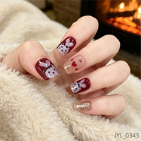 Faux ongles carrés courts en PMMA rouge foncé avec accents cœur et paillettes, prêts à poser