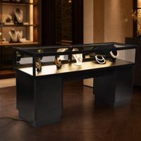 Table de présentation de bijoux moderne de luxe, cadre en métal noir, éclairage LED, vitrine en verre pour l'exposition de colliers et de bagues