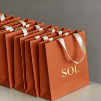 Sac en papier texturé noir gaufré de luxe 2026 avec logo personnalisé et poignée en ruban gros-grain pour emballage cadeau