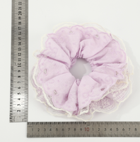 Bandeau pour cheveux avec dentelle ajourée en forme de cœur et cordon à franges pour une coiffure chignon douce et charmante.