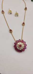 Ensemble de pendentifs fleuris plaqués or rubis, comprenant un pendentif floral central avec des pierres rouges et des accents blancs, et une chaîne délicate. - Product Image 6