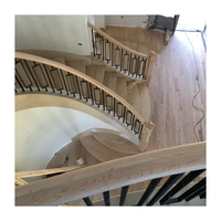 Escalier courbé à quart de tour avec marches en érable et poutre intérieure métallique, conception gain de place pour entrée d'appartement