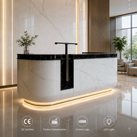 Comptoir de réception en marbre blanc avec plateau en marbre noir, éclairage LED, pour hôtel de luxe, vente en gros, directement de l'usine, logo personnalisé