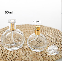 Vente en gros de flacons de parfum ronds plats transparents élégants en verre 30ml 50ml avec bouchon en plastique et emballage personnalisé