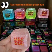 Cube anti-stress translucide à texture gelée, avec paillettes colorées à l'intérieur, déformable et agréable à saisir pour soulager le stress.