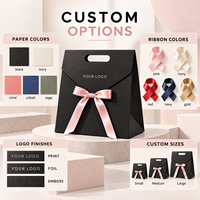 Sac en papier mat noir personnalisé OEM ODM avec logo et nœud en ruban rose, emballage cadeau de luxe en carton pour boutique