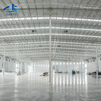 Bâtiment d'usine à structure métallique avec lignes de production et zones d'équipement