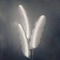 Support créatif de fleur de fond de scène de mariage de feuilles de bananier rougeoyantes acryliques avec des lumières de plume de LED