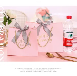 Bolsa de regalo de papel de embalaje rosa con logotipo personalizado de lujo a precio de fábrica para fiesta de boda con asa y bolsa de regalo con cinta