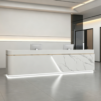 Bureau d'accueil moderne sur mesure effet marbre avec accents métalliques et éclairage LED pour bureau d'entreprise ou hôtel