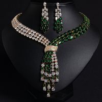 Ensemble collier et boucles d'oreilles en zircone vert émeraude, plaqué or, avec nœud croisé et franges asymétriques multi-rangs