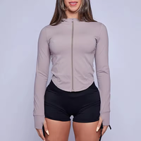 Veste athlétique d'entraînement pour femmes OEM veste de course courte à fermeture éclair légère et coupe ajustée avec trous pour les pouces