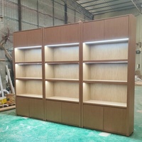 Cremefarbener Wandmontierter Umweltfreundlicher Langlebiger Einzelhandels-Präsentationsschrank mit LED-Beleuchtung MDF Holzmaserung Kommerzieller Wandvitrinenschrank für Geschäfte