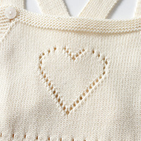 Combinaison bébé en coton pur minimaliste, tricotée, avec détail cœur ajouré, bretelles croisées, sans manches