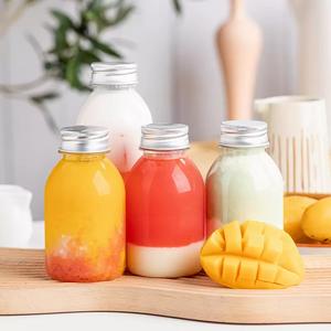 Vaso de plástico Botellas de jugo Botella de jugo de plástico <span class=keywords><strong>PET</strong></span> vacía Botella de bebida redonda única transparente sin BPA con tapas - Product Image 1