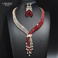 Ensemble collier et boucles d'oreilles en zircone vert émeraude, plaqué or, avec nœud croisé et franges asymétriques multi-rangs