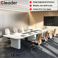 Table de conférence exécutive Racetrack avec plateau blanc mat, base sur pied, chemin de câbles et module d'alimentation pour bureau moderne