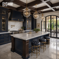 Armoires de cuisine de luxe bleu prussien, lanternes en laiton, îlot en marbre Statuario, projet de menuiserie sur mesure style manoir français