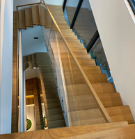 Escalier en bois design avec support en acier noir et verre transparent, style intérieur lumineux