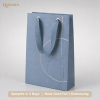 Sac en papier personnalisé OEM avec poignée en ruban gros-grain géométrique gaufré feuille d'or rose bleu pour bijouterie et boutique de montres