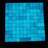 Mosaïque de verre bleu brillant brillant dans l'obscurité de la piscine