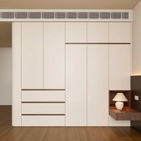 Armoire de chambre à coucher moderne blanche personnalisée avec éclairage LED intégré et une combinaison d'étagères ouvertes et de compartiments de rangement