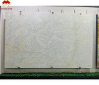 Dalle naturelle rétro-éclairée par LED de conception moderne de marbre d'onyx blanc de fissure de glace translucide pour le mur de fond de villa prix par mètre carré