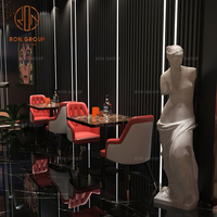 Table moderne en marbre noir avec ensemble de chaises en cuir, banquette rouge, tabourets de bar en rouge et blanc pour les repas des restaurants