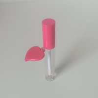 Tubo cilíndrico para brillo labial con tapa en espiral, etiqueta en forma de corazón rosa, material plástico