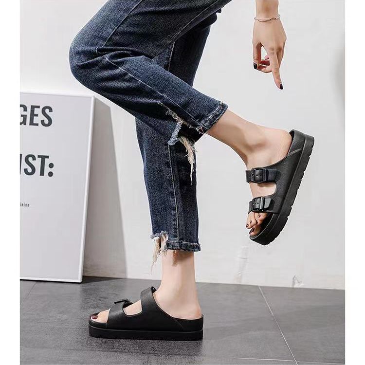 Sandalias negras de las diapositivas
