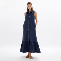 Gaun kemeja midi wanita custom grosir warna biru navy tanpa lengan, kerah runcing, kancing depan, saku samping, dan detail ruffle bertingkat.