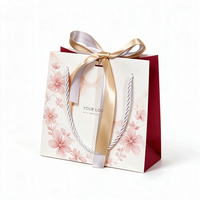 Sac shopping en papier marbré rose avec logo personnalisé, décoration nœud en satin et poignée torsadée en corde pour emballage cadeau de boutique cosmétique