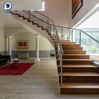 Escalier en arc courbé sur mesure en métal avec garde-corps en verre pour la rénovation intérieure de résidences haut de gamme