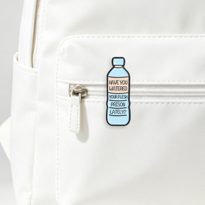 Spilla in smalto 'Have You Watered Your Flesh Prison Lately' con design a forma di bottiglia d'acqua e testo sardonico, distintivo per borsa - Product Image 1