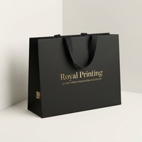 Sac en papier noir mat horizontal de luxe personnalisé avec logo en feuille d'or et poignée en ruban noir pour emballage de bijoux de boutique