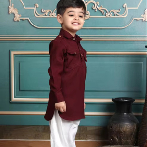 Niño sonriente con kurta color granate y pantalones blancos posando en interiores, atuendo étnico festivo, retrato infantil, niños con estilo. - Product Image 1