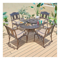 ronde de foyer de barbecue coulé dans le jardin d'un hôtel mobilier d'extérieur ensemble table à manger et chaises en aluminium