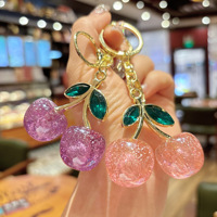 Al por mayor Llavero de moda ligero de cristal con cereza, de resina brillante con diseño de fruta y aleación de oro, colgante para bolso y llavero para coche