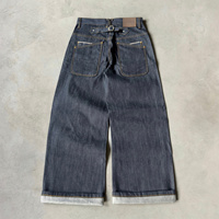 Jeans en denim brut à poche incurvée et boucle arrière, braguette boutonnée, jambe large, denim selvedge, double poche arrière, boucles croisées, jeans baggy