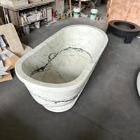 Baignoire autoportante ovale en marbre blanc avec rebord large et base sculpturale pour villas et hôtels