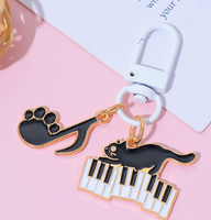 Porte-clés en alliage de zinc avec motif de petit chat noir musical de dessin animé et notes de piano, accessoire de sac mignon et original pour hommes et femmes