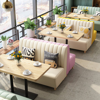 Ensemble de salle à manger avec fauteuils courbes aux couleurs pastel et table en bois clair, banquette et chaises pour restaurant de restauration rapide (hamburger)