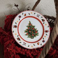 Assiette de Noël en céramique style rétro, motif de conte de fées avec Père Noël, cheval à bascule, sapin, agneau de Noël, et bordure géométrique rouge, idéale pour les fêtes