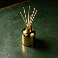Bouteille diffuseur d'arômes avec revêtement électrolytique doré, col vissé et bouchon, et bâtonnets aromatiques personnalisables en couleur