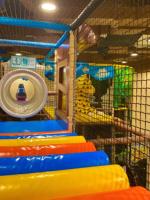 Parc d'attractions intérieur amusant avec toboggans lumineux, défis de puzzle, trampolines circulaires et équitation pour enfants