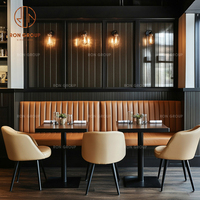 Ensemble de mobilier de restaurant moderne et écologique : banquette en cuir marron foncé en forme de L, tables carrées et chaises-canapés pour café et salle à manger